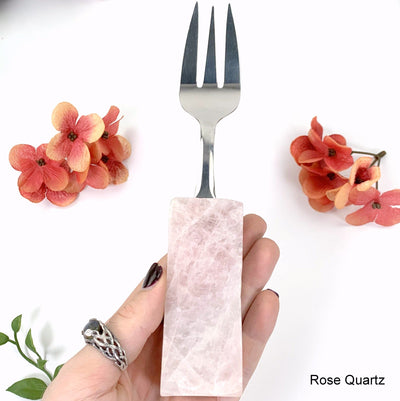 rose quartz fork in hand with white background