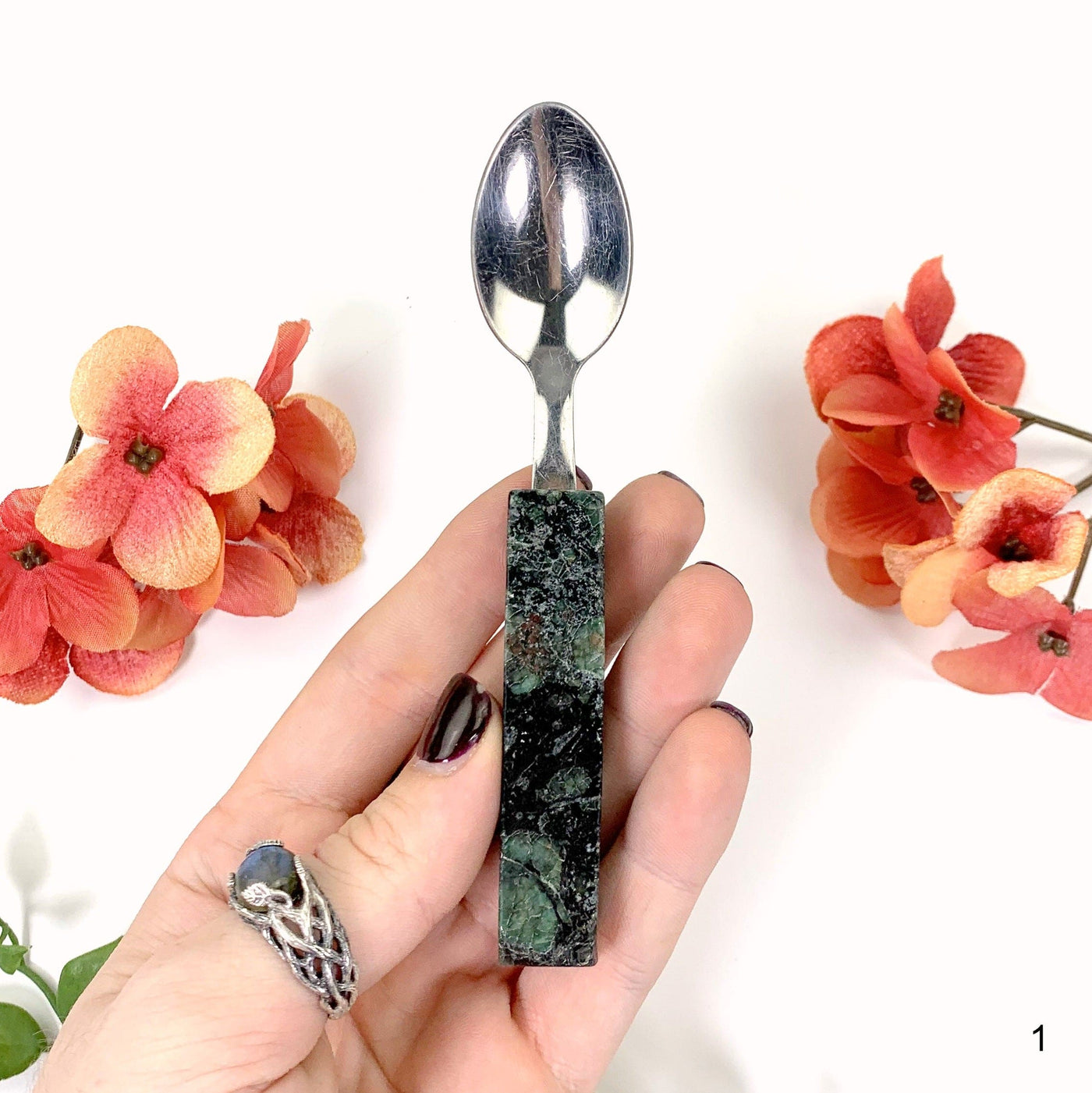 first emerald spoon in hand with white background
