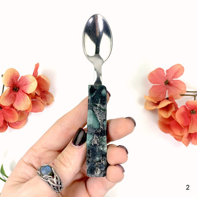 second emerald spoon in hand with white background