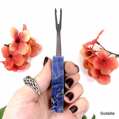 sodalite cocktail fork in hand with white background