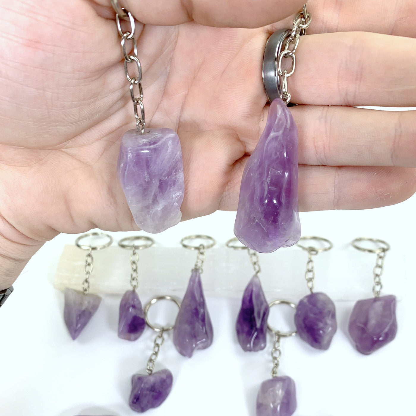 olished Amethyst Keychains with silver links and ring hoop displayed to show color and characteristic variations in hand