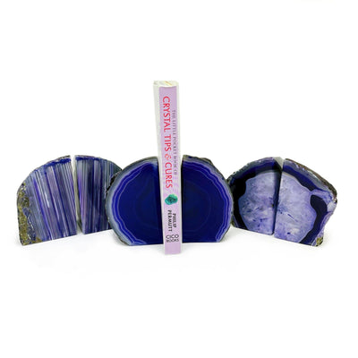 Three mini purple agate geode bookends displayed with a white background. One bookend displayed holding a book.