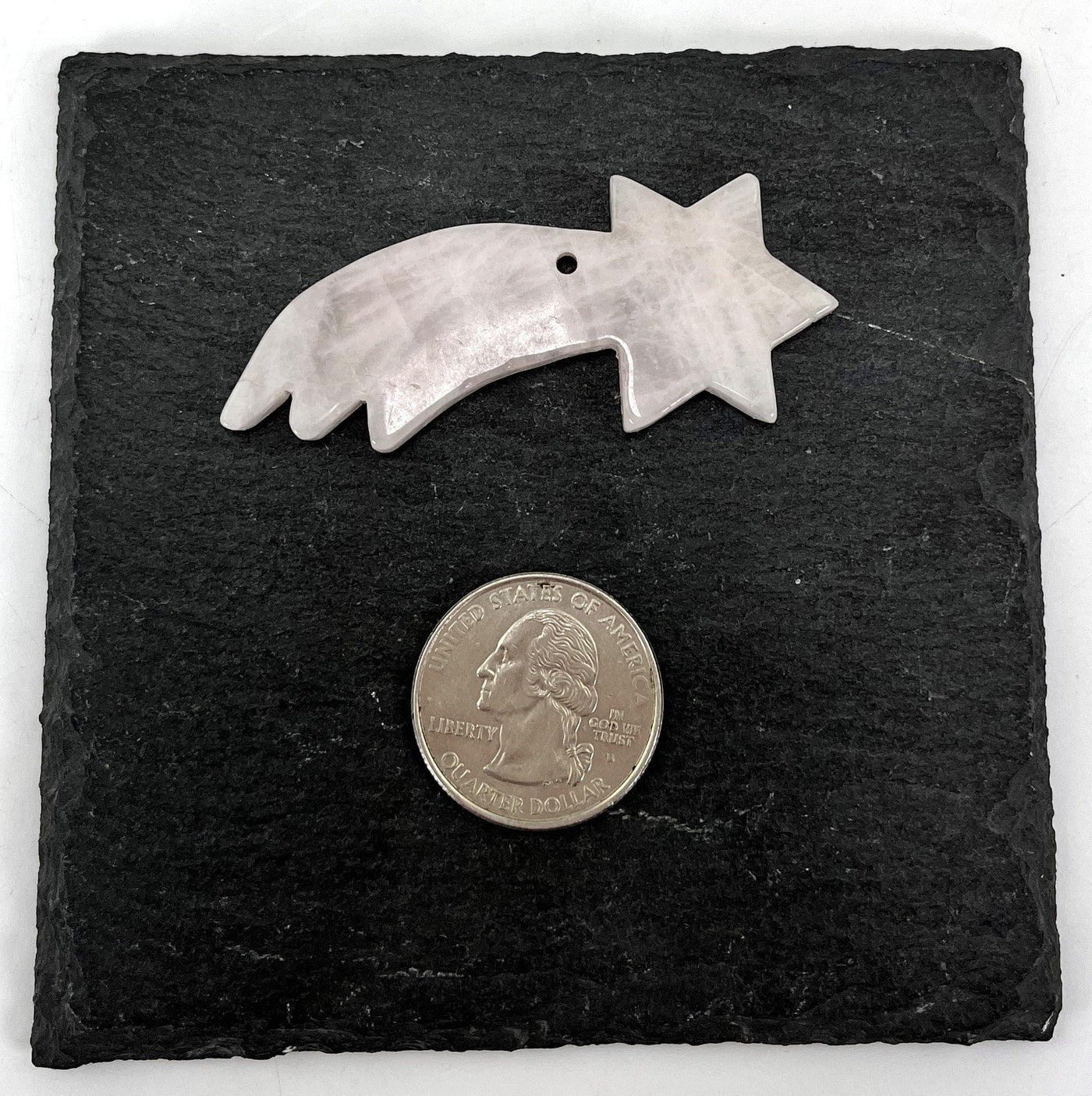 shooting star pendant shown next to a quarter for size reference