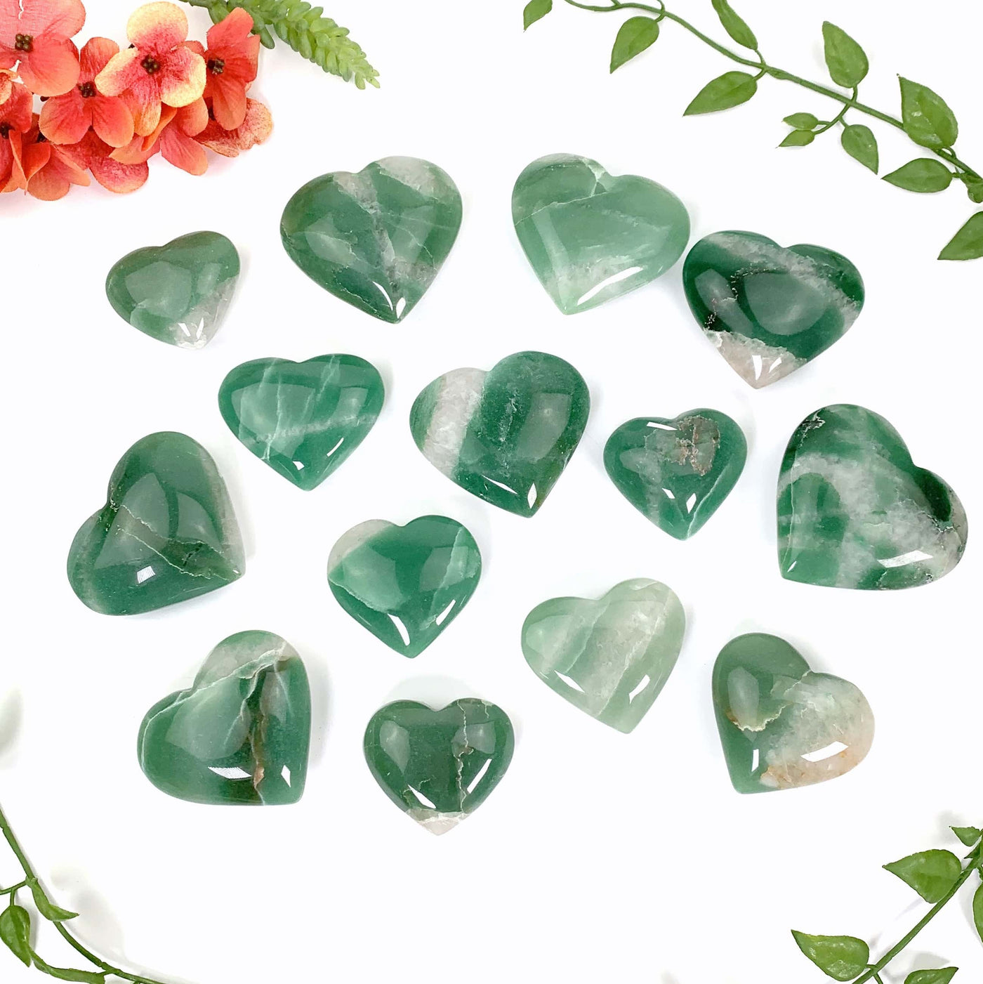 14 green quartz heart laid out on a white background