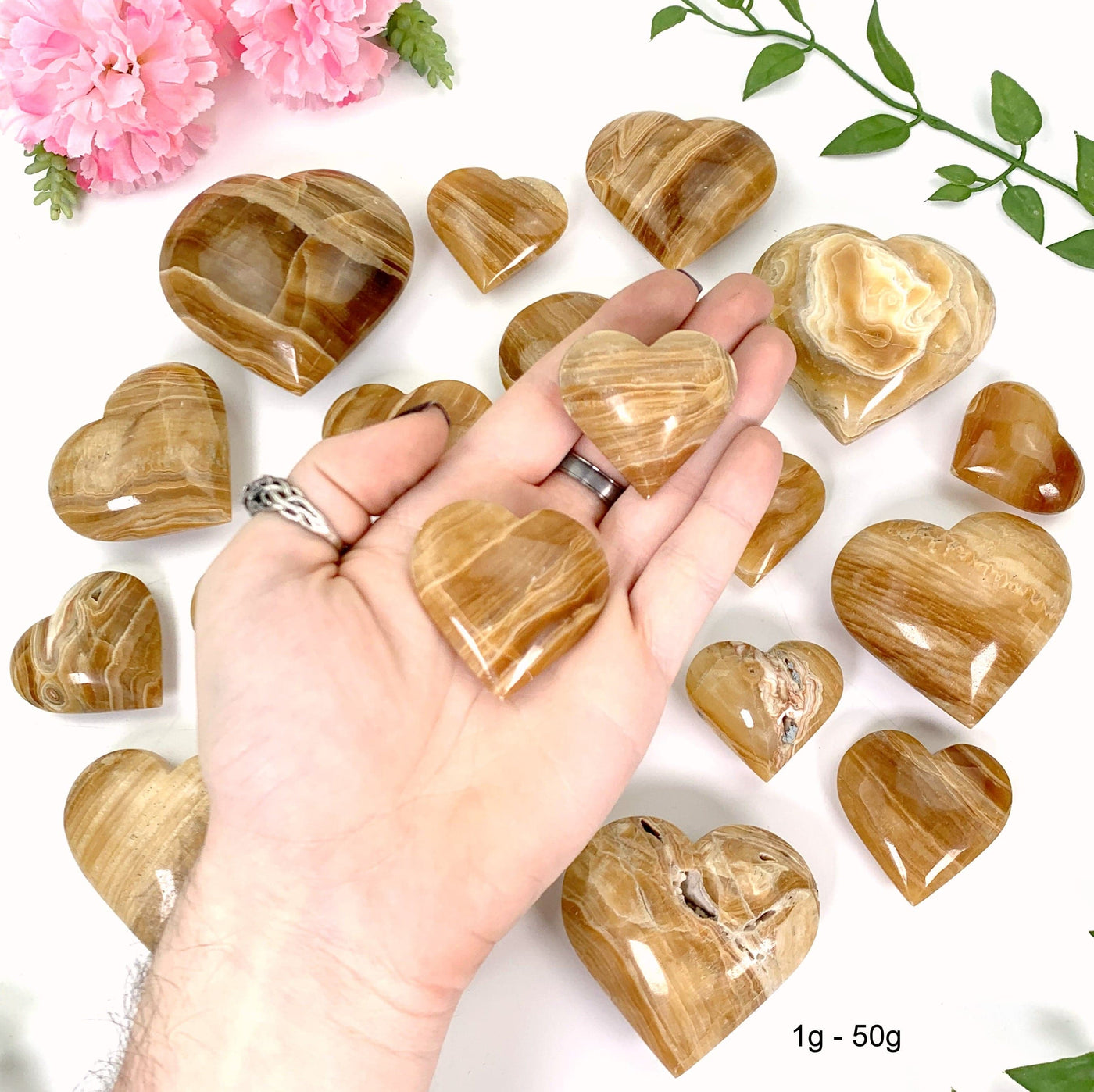 2 1gram - 50 gram hearts in hand with a white background