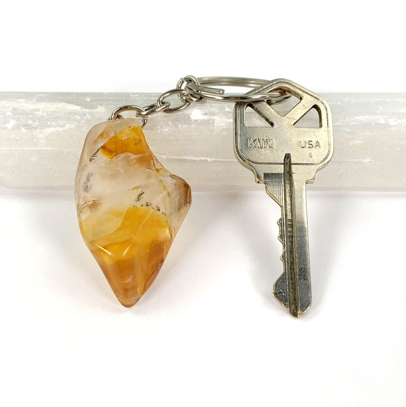 Polished Golden Healer Quartz Keychain next to key for size comparison