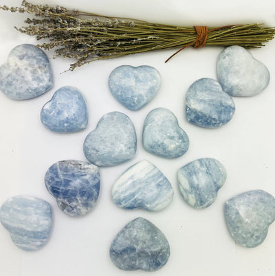Blue Calcite Hearts on display on a table with flowers