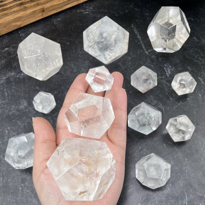 multiple crystal quartz dodecahedron shaped stones in hand for size reference 