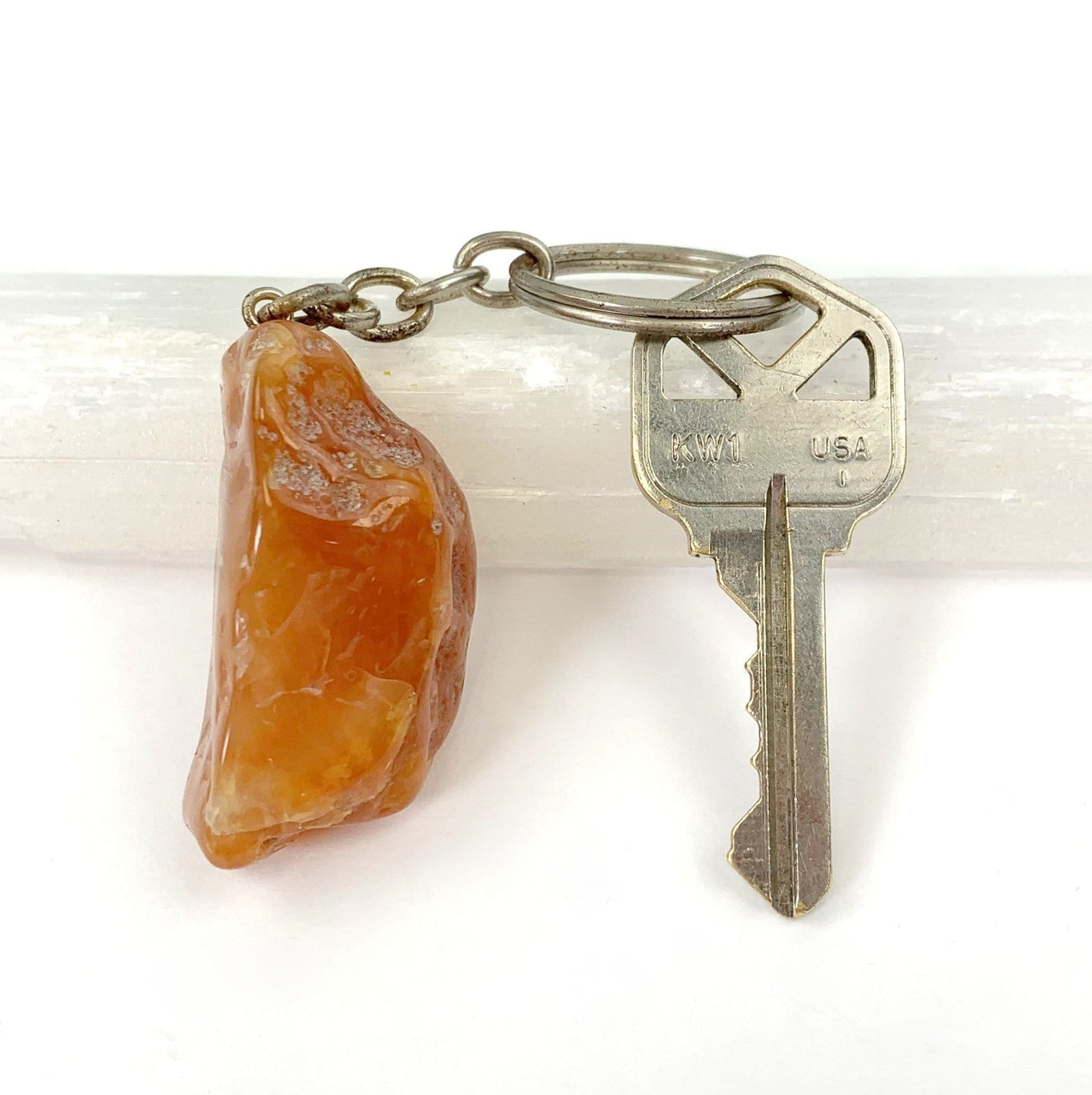 tumbled carnelian keychain displayed next to a key for size reference with silver link and hoop ring