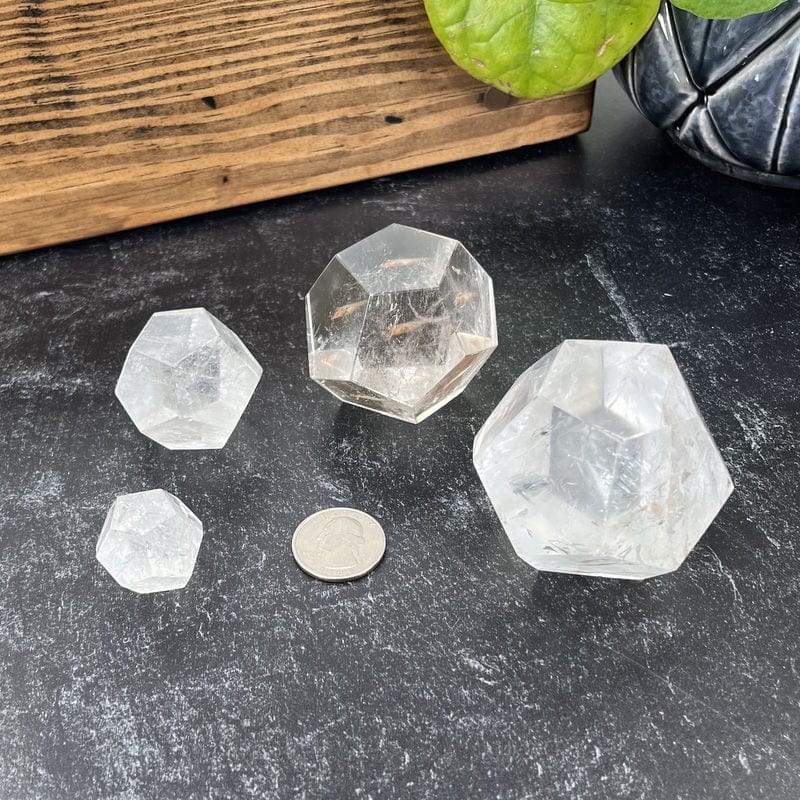 multiple crystal quartz dodecahedron shaped stones next to  quarter for size reference 