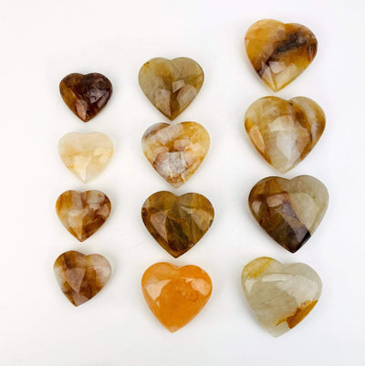 various sizes of Golden Healer Polished Hearts on white background