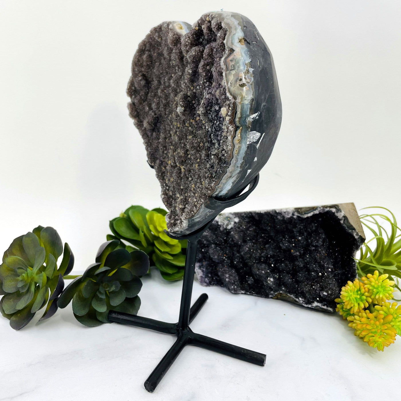 Side view of the black amethyst heart on a metal stand.