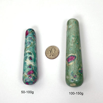 ruby fuchsite massage wands next to a quarter for size reference and the weight in grams 