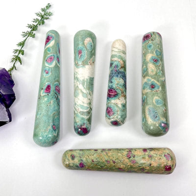multiple ruby fuchsite massage wands displaying the different sizes and color patterns  