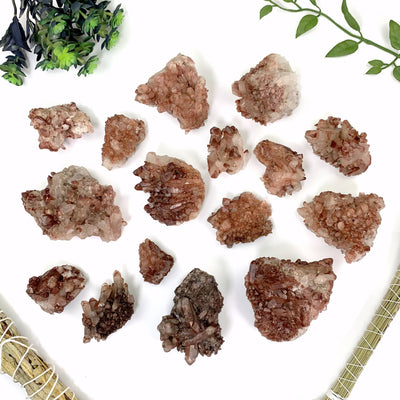 an assortment of orange brown lithium quartz clusters on a white background