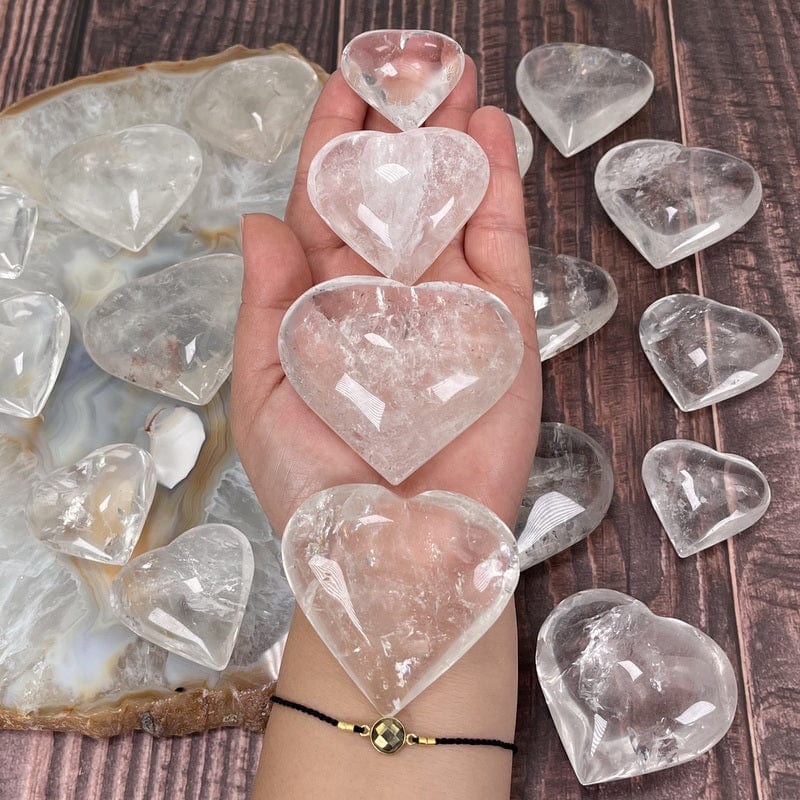 multiple crystal quartz hearts in hand for size reference 