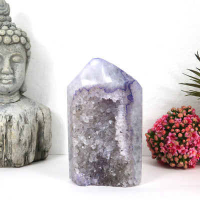 Dyed Amethyst crystal Polished tower with decorations in the background
