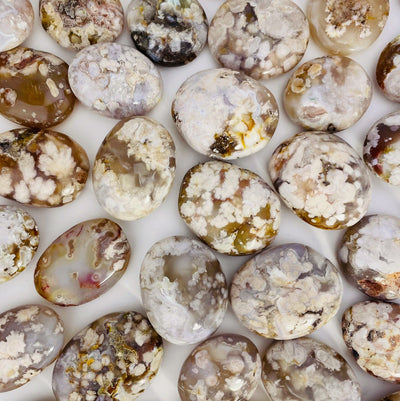 A close view of Flower Agate Polished Palm Stone Showing different size and colors shapes.