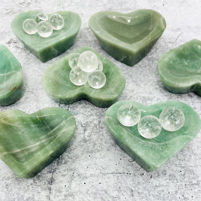 side view of multiple Green Aventurine Stone Heart Dishes for thickness reference