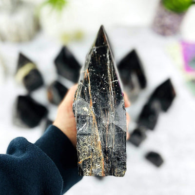 Black Tourmaline Semi Polished Points in hand for size reference