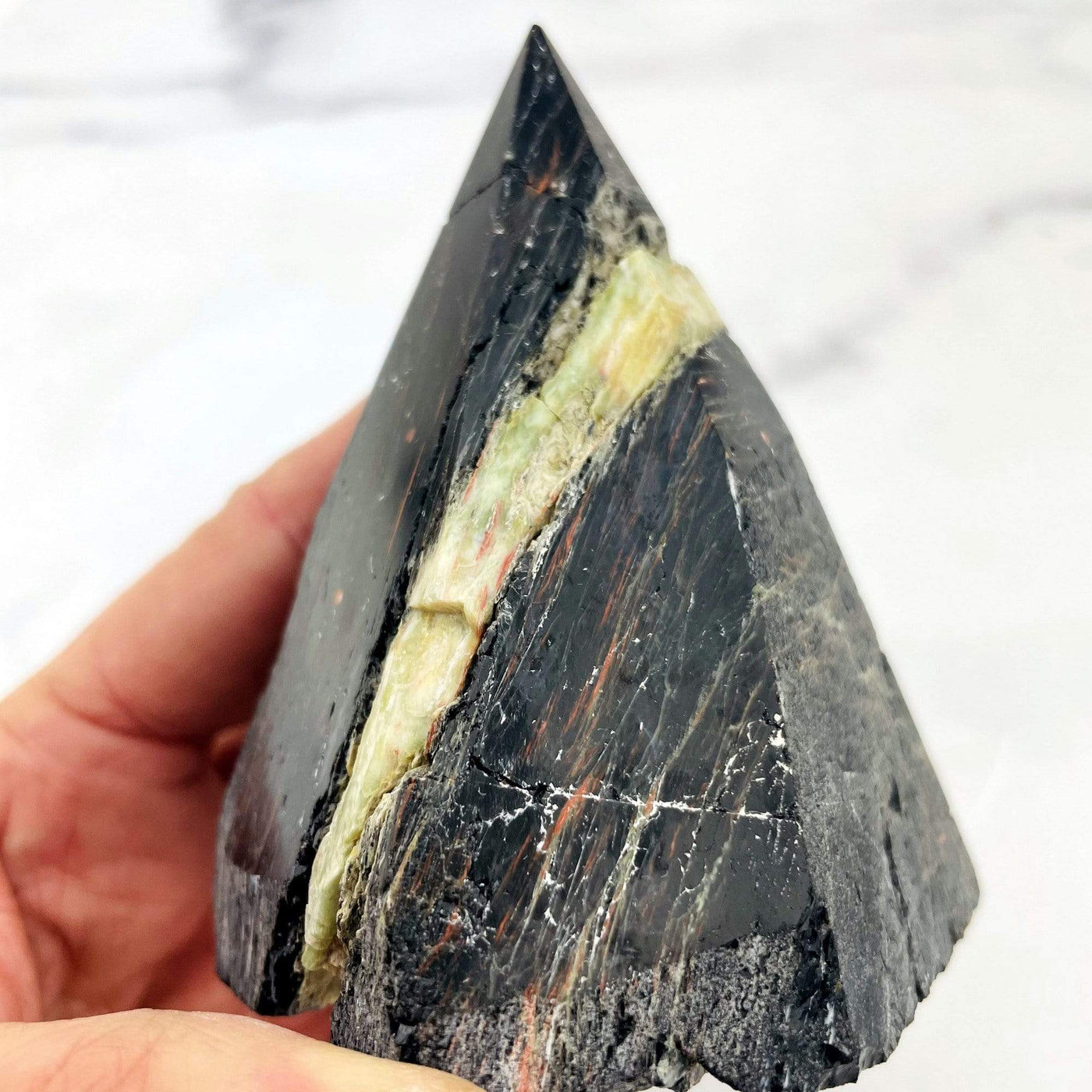 up close of the black tourmaline point on white background