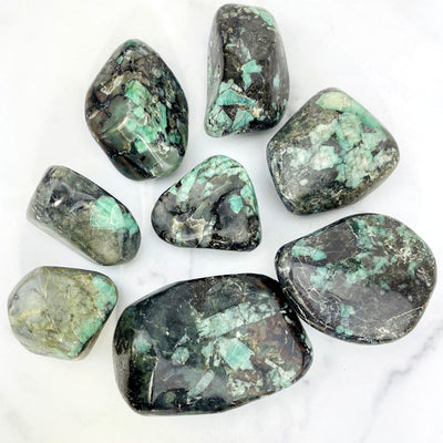 Emerald Freeform Tumbled Polished Stone displayed next to each other showing big and small size.
