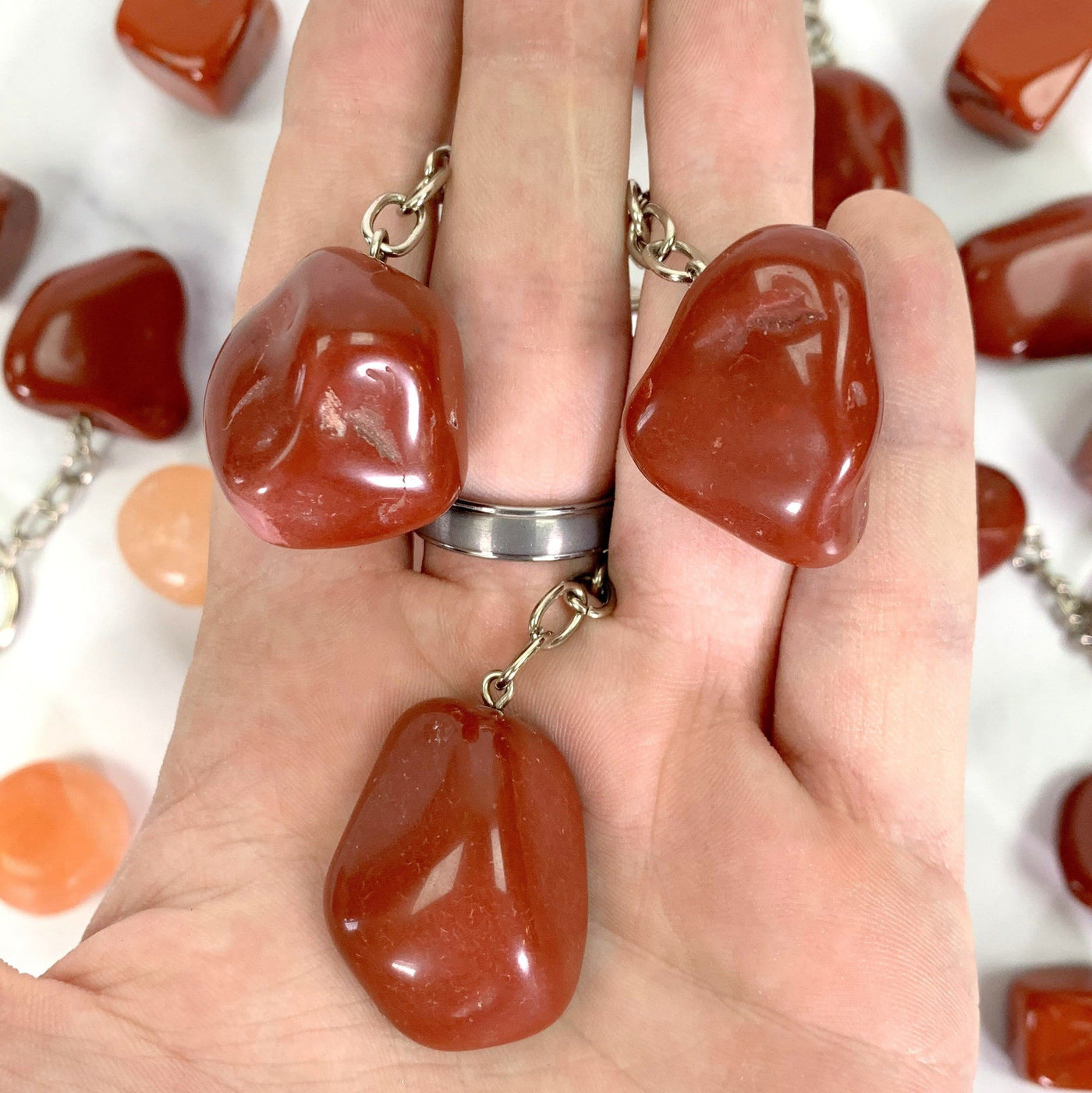 Tumbled Red Jasper Keychains in hand for size reference