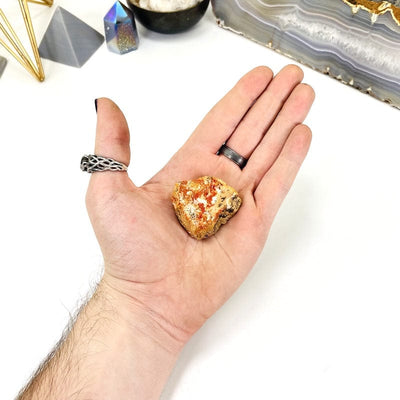 natural vanadinite cluster in hand with a white background