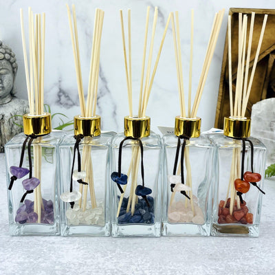 Tumbled Stone Diffuser Bottle--front shot view of stones inside glass bottle with wooden sticks on table.