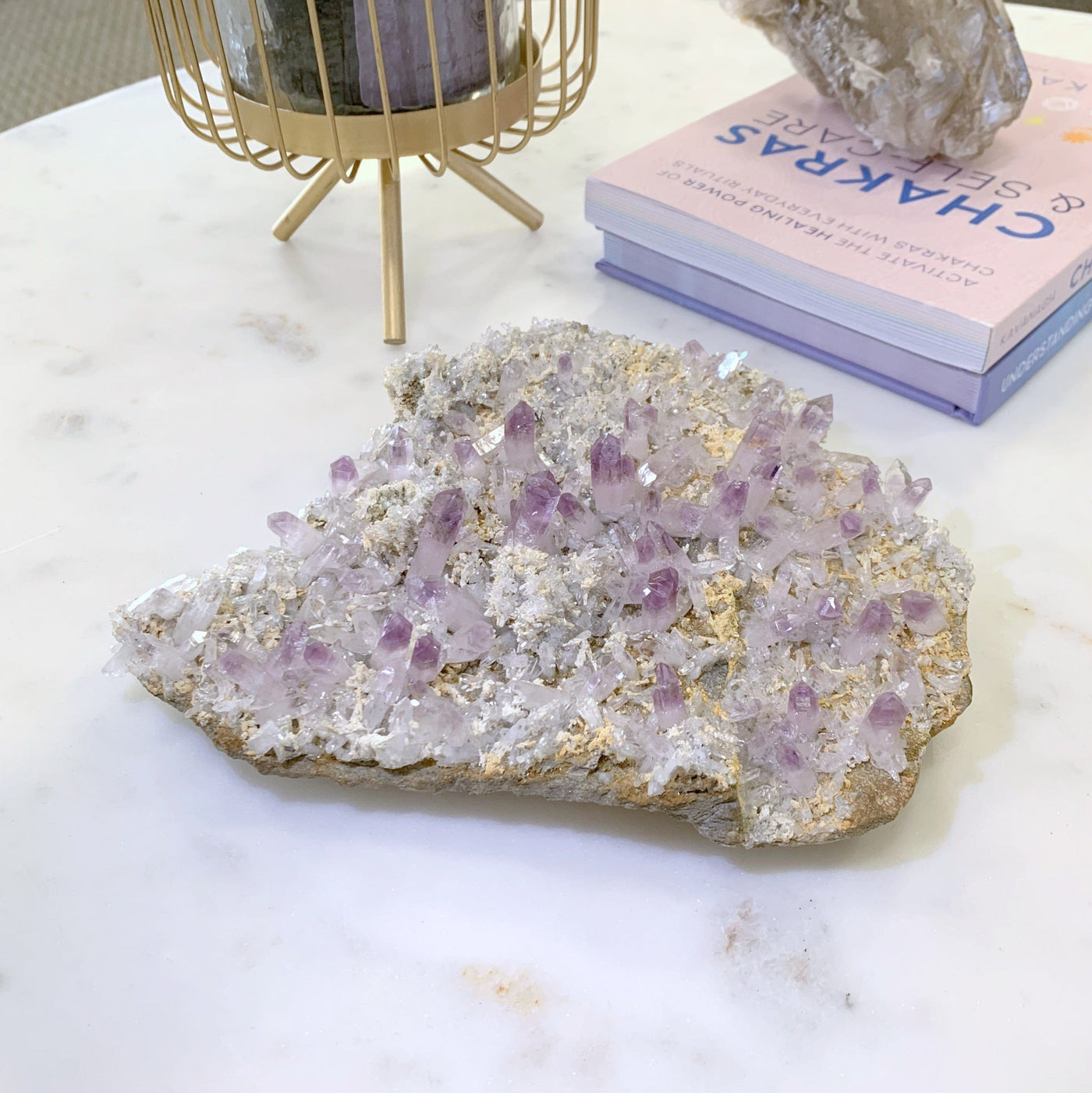 veracruz amethyst on white coffee table next to books and candle