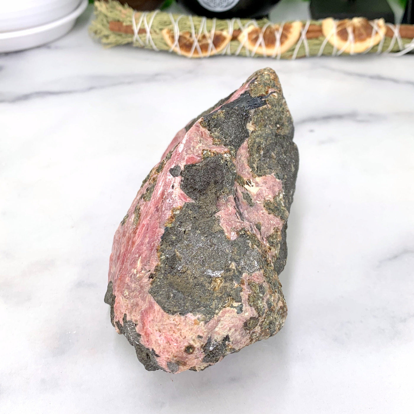 side angle of rhodonite stone on marble background