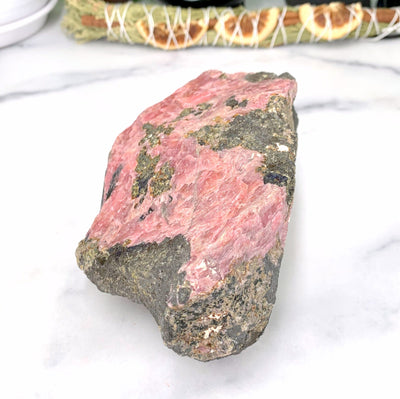 side angle of rhodonite stone on marble background