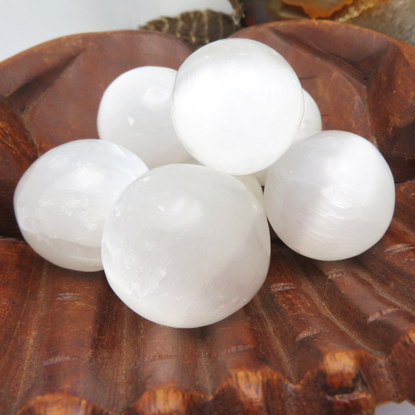 close up of selenite spheres in hand bowl for details and possible variations
