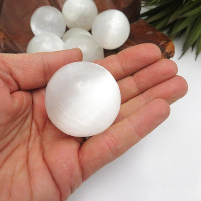 selenite sphere in hand for approximate size reference