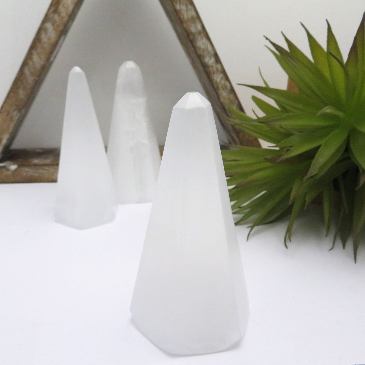 close up of selenite polished obelisk for details with others on display in background