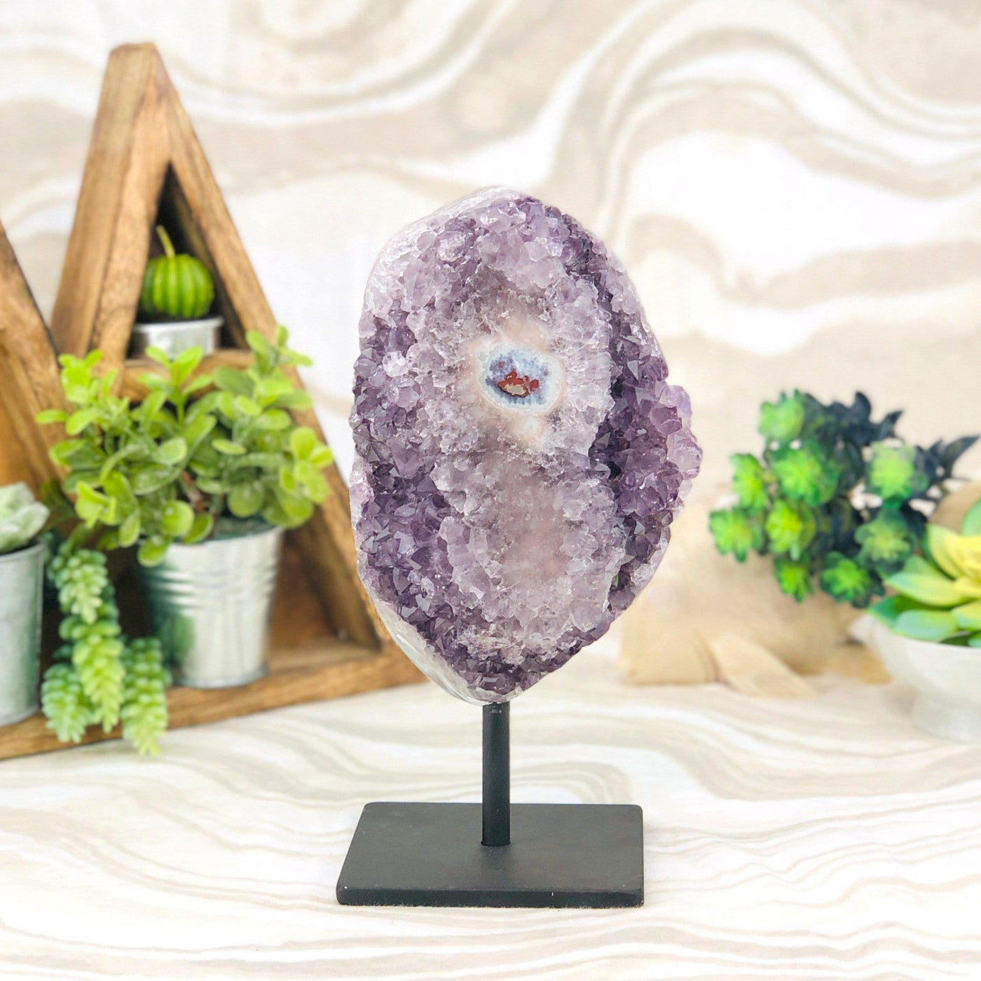 Amethyst Crystal Purple Druzy Semi Polished Stalactite Geode on Stand with decorations in the background