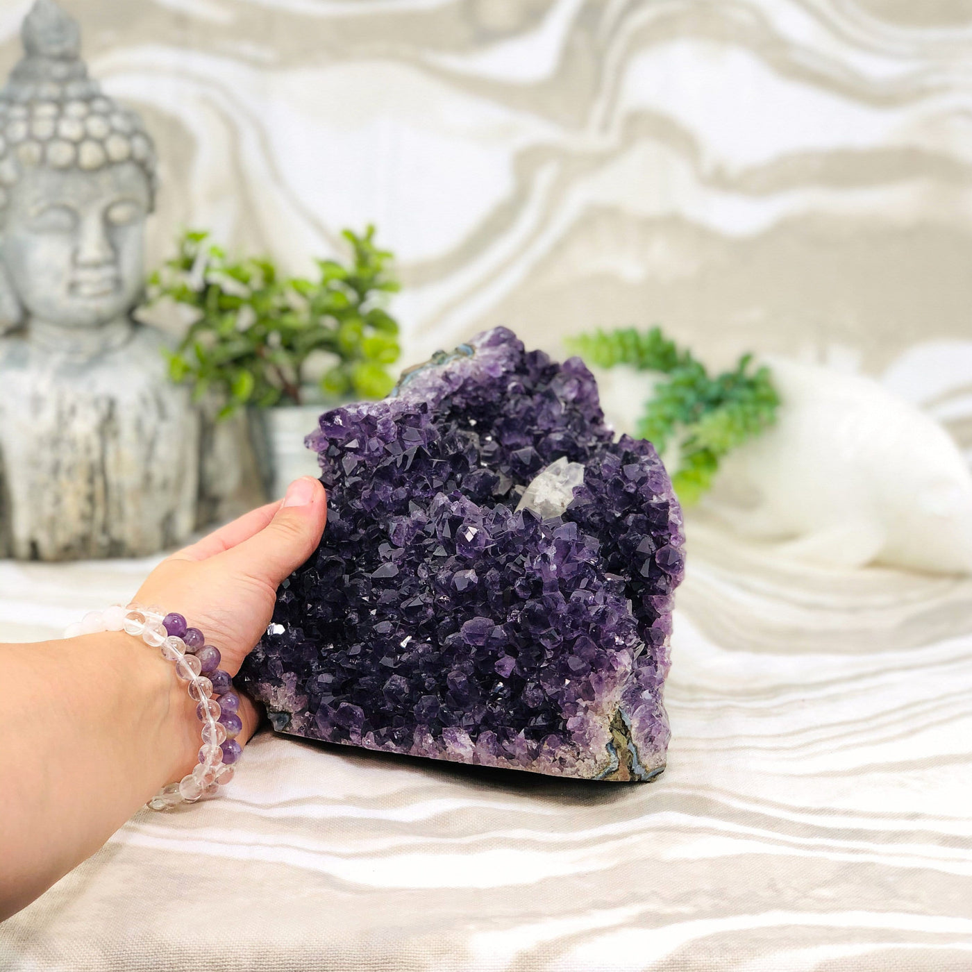 hand holding up Amethyst Cluster with Calcite with decorations 