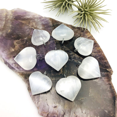 selenite heart pendants on display for possible variations
