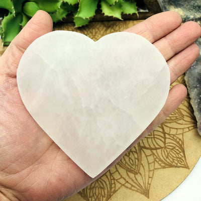 selenite flat heart in hand for size reference