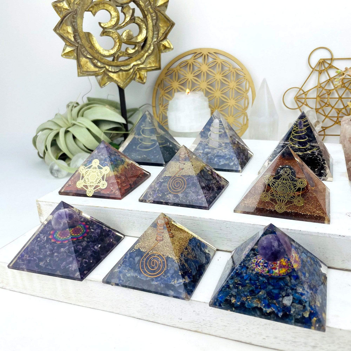 9 different Orgone Crystal Point Pyramids displayed, all containing different stones inside.