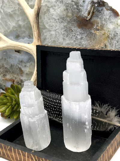 2 selenite towers in a wood box as a display with an agate as background decoration