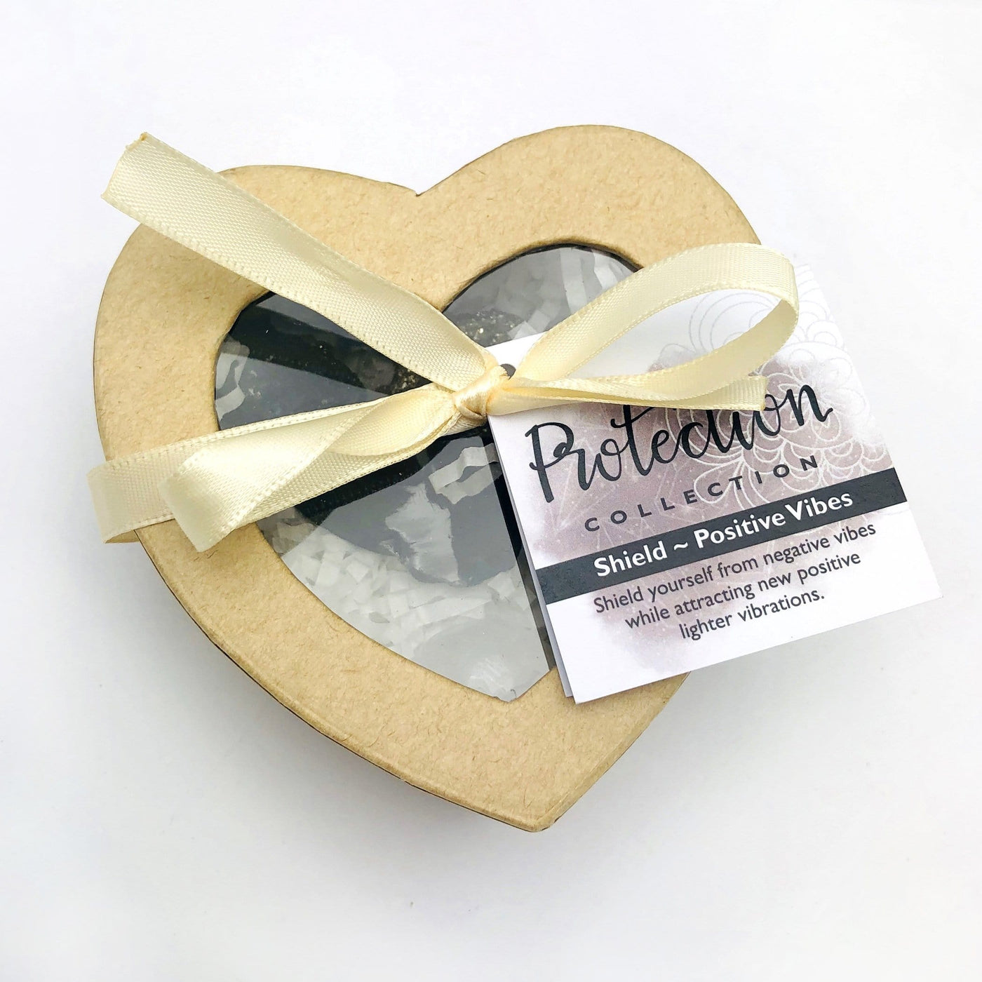 heart shaped box with ribbon and detail card tag with gemstones inside displayed on white background