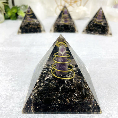 Orgone Tourmaline with Amethyst Point Pyramid displayed up close to show gold wire and metal shavings