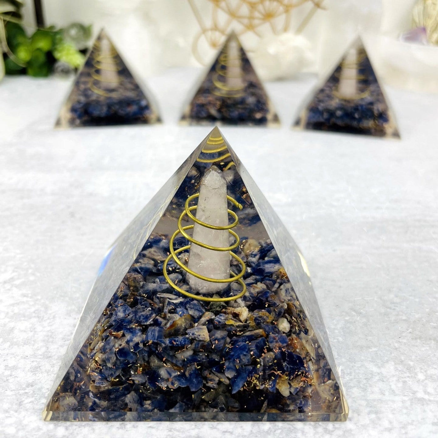up close photo of the sodalite pyramid to view rose quartz point with wire coil wrapped around sodalite chips metal shavings 