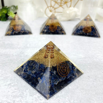 4 Orgone Sodalite with Crystal Point Pyramid displayed, 3 out of focus. 1 in focus is angled to display the side view.