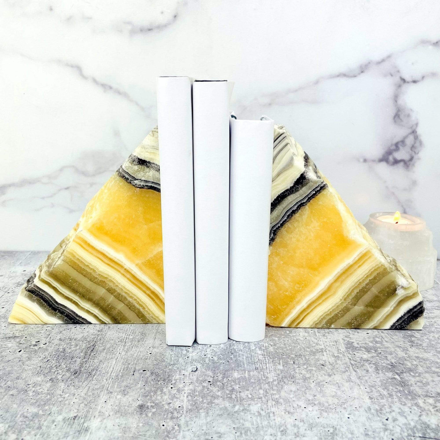 zebra onyx bookends  holding up 3 books on marble background