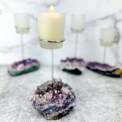 Picture of amethyst cluster base with candle inside, candle is on.