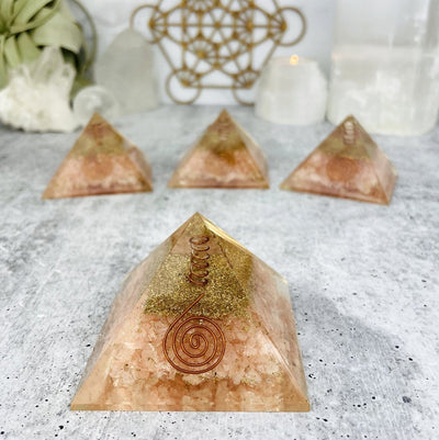 Orgone Pyramid displayed to show contents inside Metal Shavings and Wire, Crystal Point and Rose Quartz stone chips