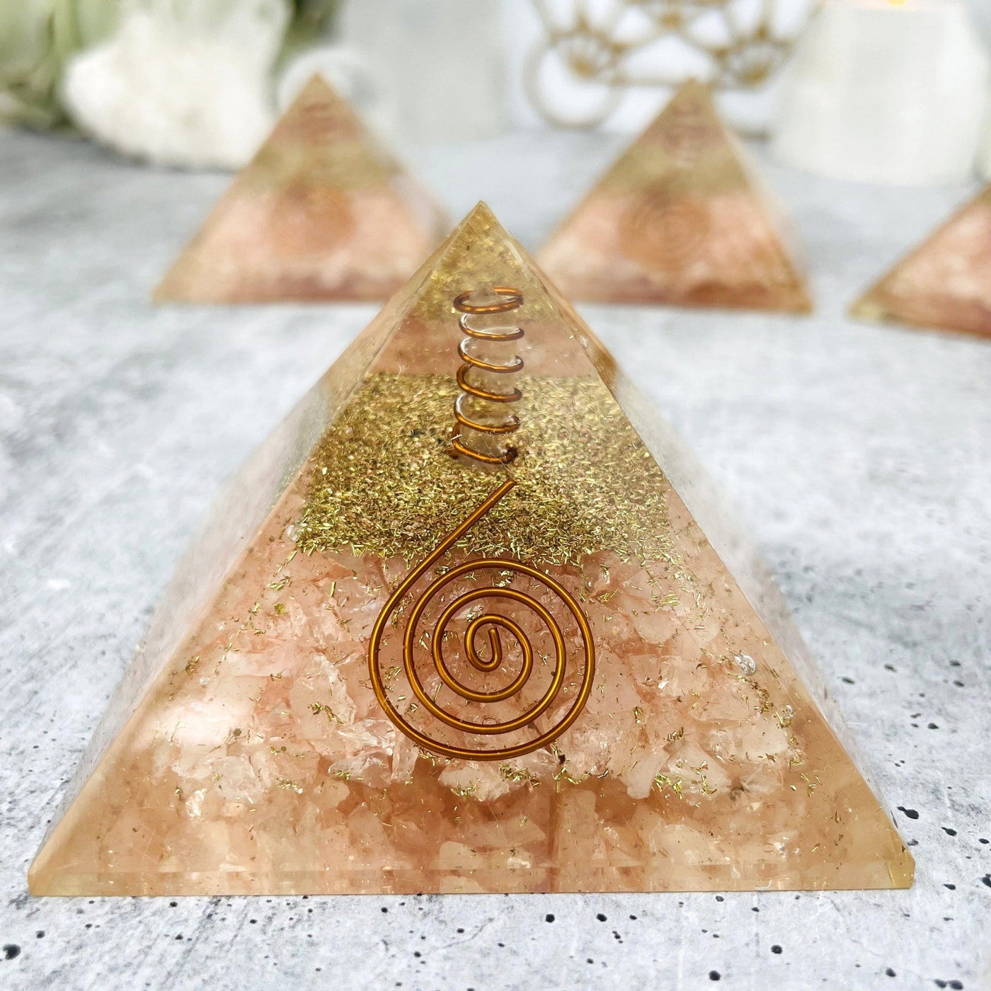 Orgone Pyramid displayed to show wire swirl on crystal quartz and one spiral wire on the front of pyramid