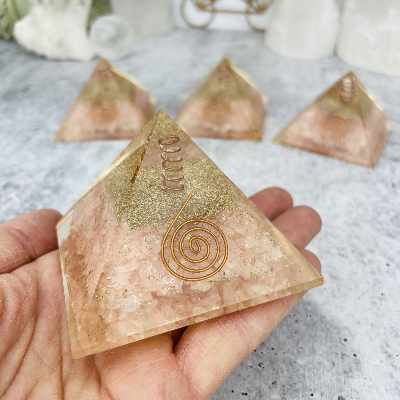 Orgone Pyramids displayed in hand to show size reference